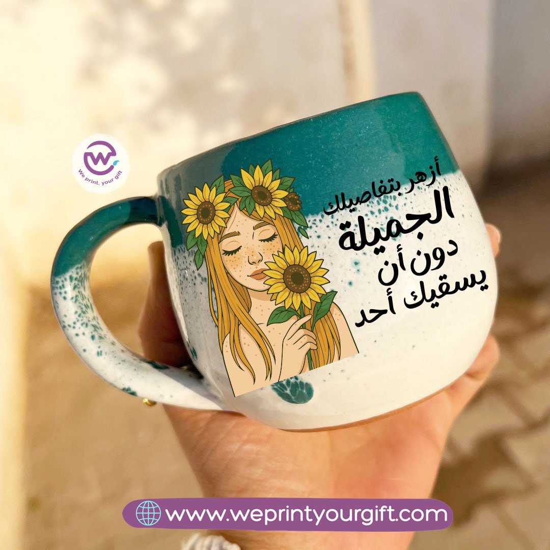 كوب خزفي مصنوع يدويًا باللونين الأخضر والأبيض مزين برسومات تحفيزية لزهرة عباد الشمس